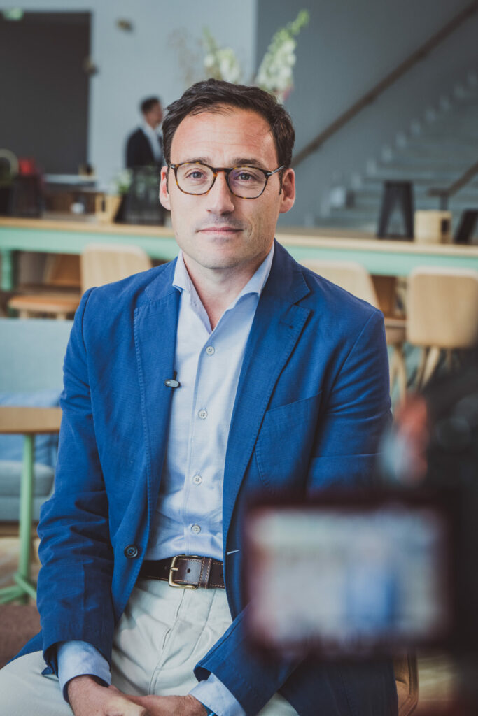 Portrait d’un participant en veste bleue pendant l’événement Deloitte