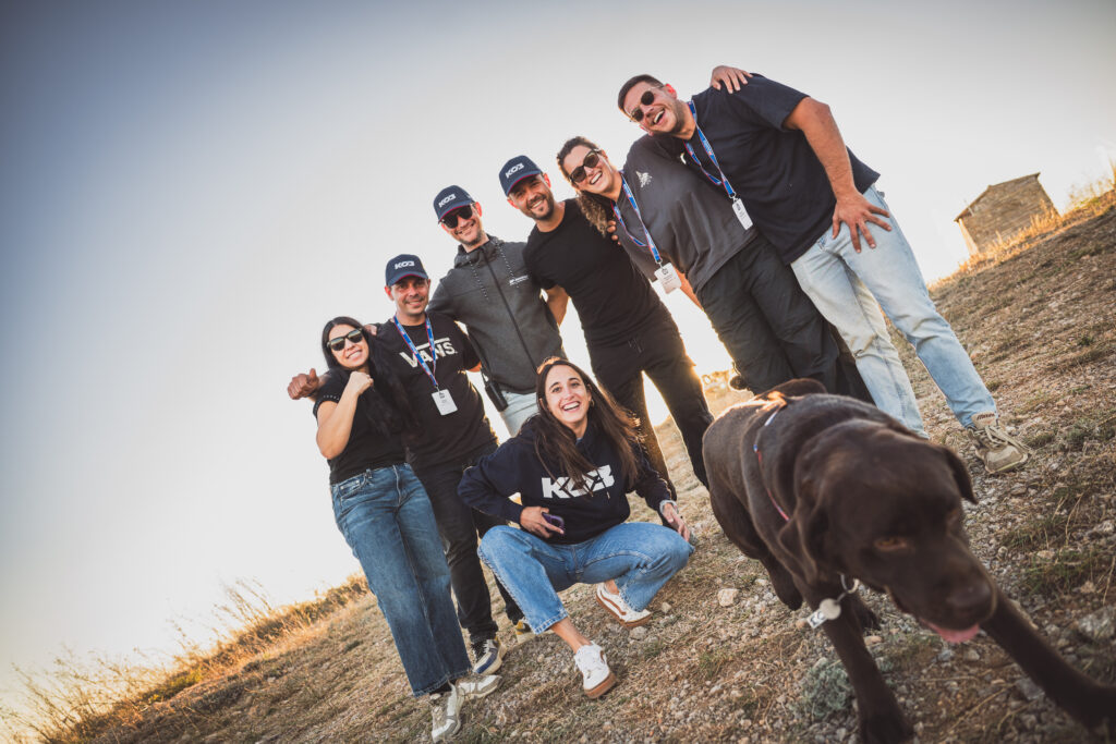 Portrait de groupe de l'équipe en tenue sur un chemin de terre, avec un chien noir, reportage BF Goodrich