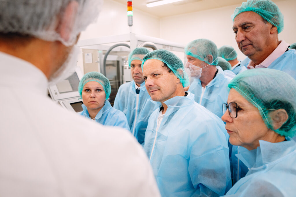Visiteurs en tenue de protection écoutant une présentation lors de la visite de l'usine pharmaceutique MAYOLY à Auxerre