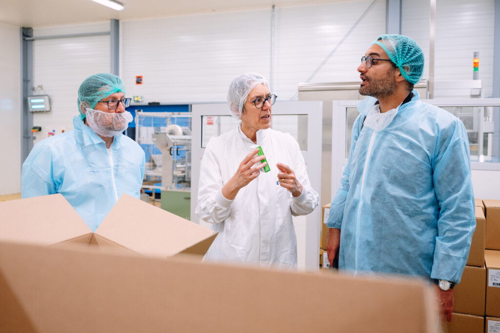 Collaborateurs et visiteurs échangeant en zone de production de l'usine MAYOLY à Auxerre