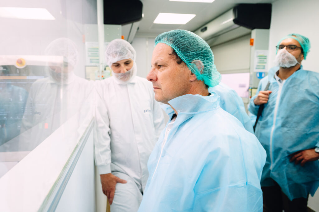 Portrait d'un visiteur en tenue de protection pendant la visite de l'usine pharmaceutique MAYOLY