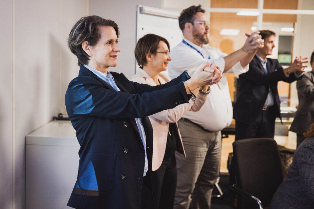 OMS Synergie : intervenants debout qui échangent devant les participants