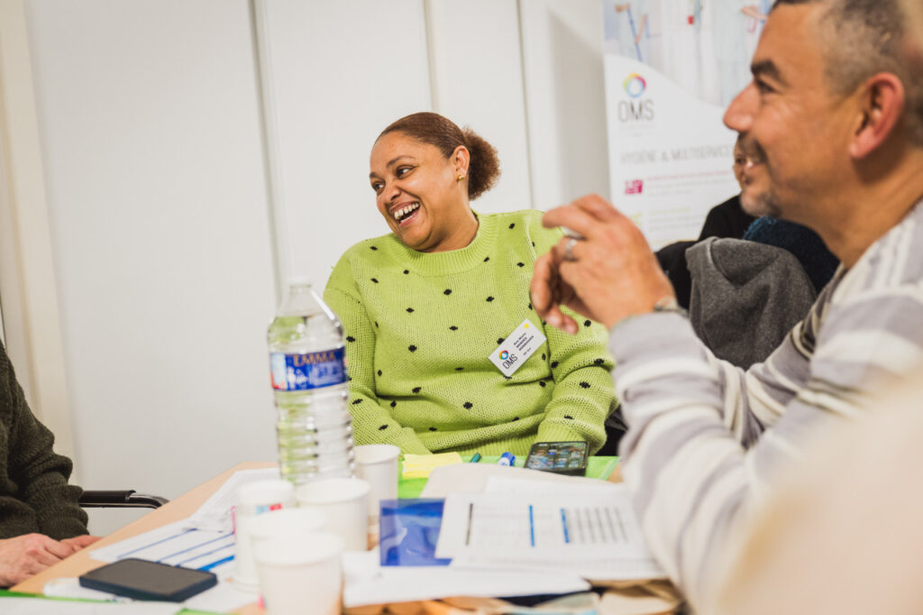 OMS Synergie : collaboratrice qui rit pendant un échange en groupe