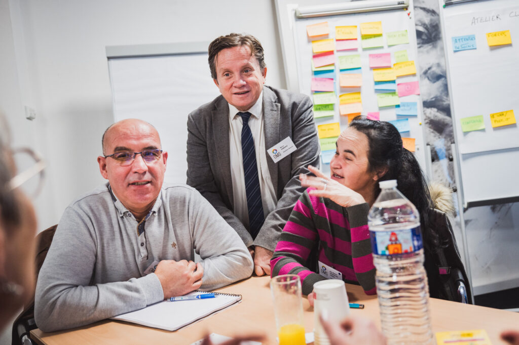OMS Synergie : échanges souriants entre collaborateurs pendant un atelier