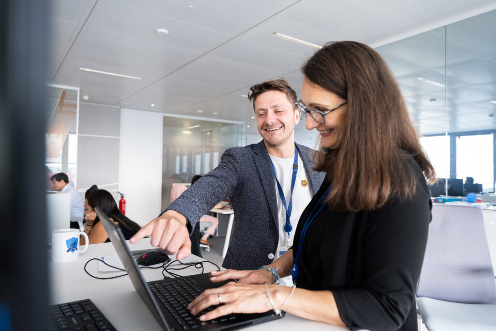 Saint-Gobain : échange entre deux collaborateurs autour d’un ordinateur portable