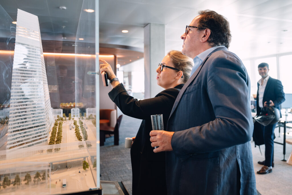 Invités observant une maquette d'architecture lors d'un événement à la Tour Triangle