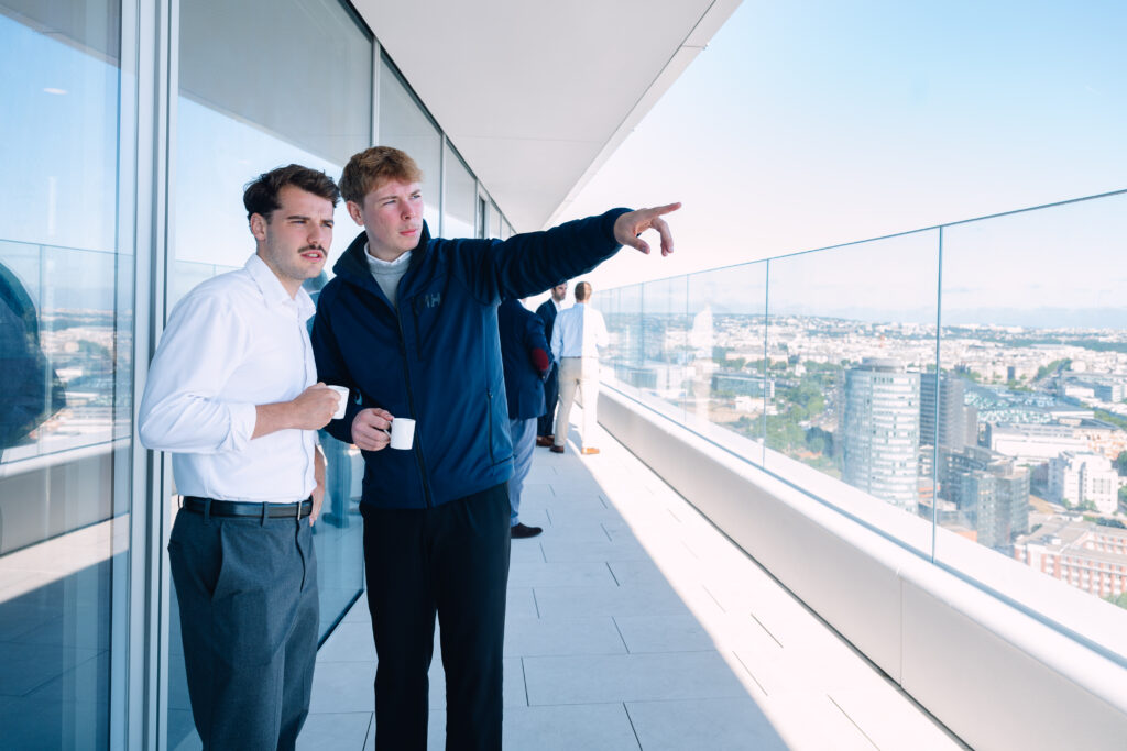 Deux participants sur le balcon observant la vue sur Paris depuis la Tour Triangle