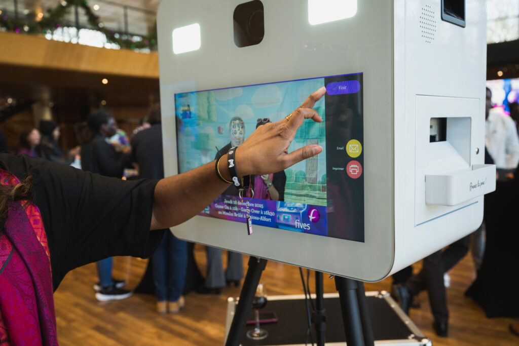 Invité touchant l'écran tactile du photobooth pour lancer une photo