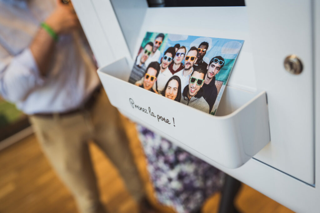 Tirage photo de groupe sorti du photobooth, dans le bac de réception, lors d'un événement d'entreprise